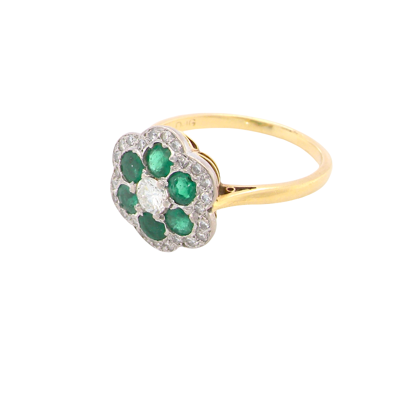 side A pretty cluster ring. Features emeralds and diamonds. Centre stone a brilliant cut white diamond, measures 4mm (0.25 carats). 