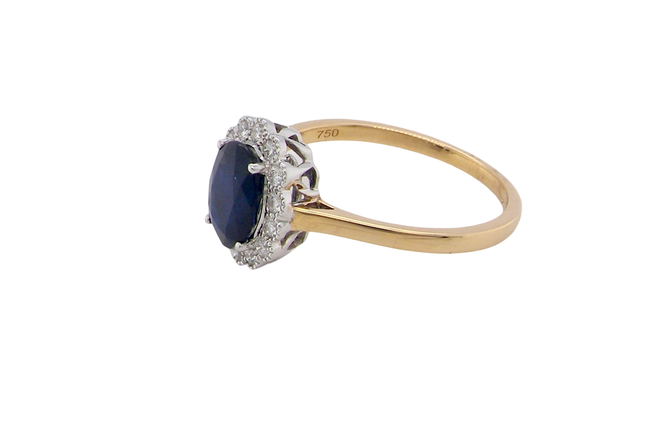 side A pretty cluster ring that features an inky black blue sapphire that measures 8x6mm. Complimented by an outer border of diamonds