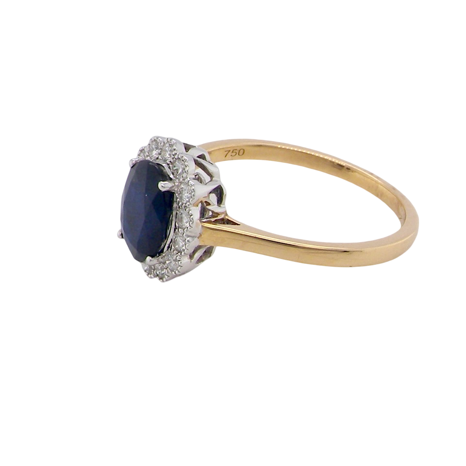 side A pretty cluster ring that features an inky black blue sapphire that measures 8x6mm. Complimented by an outer border of diamonds