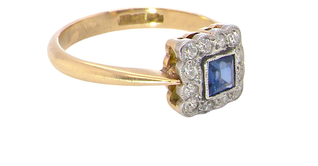 side A pretty square cluster ring. Features to the centre a cornflower blue square sapphire, 4x4mm (est 0.30 carats) mille grain set.
Complimented by a halo of twelve x 1.5 mm single cut white diamonds