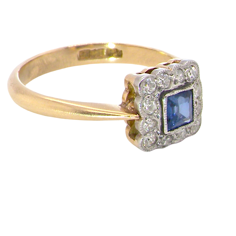 side A pretty square cluster ring. Features to the centre a cornflower blue square sapphire, 4x4mm (est 0.30 carats) mille grain set.
Complimented by a halo of twelve x 1.5 mm single cut white diamonds