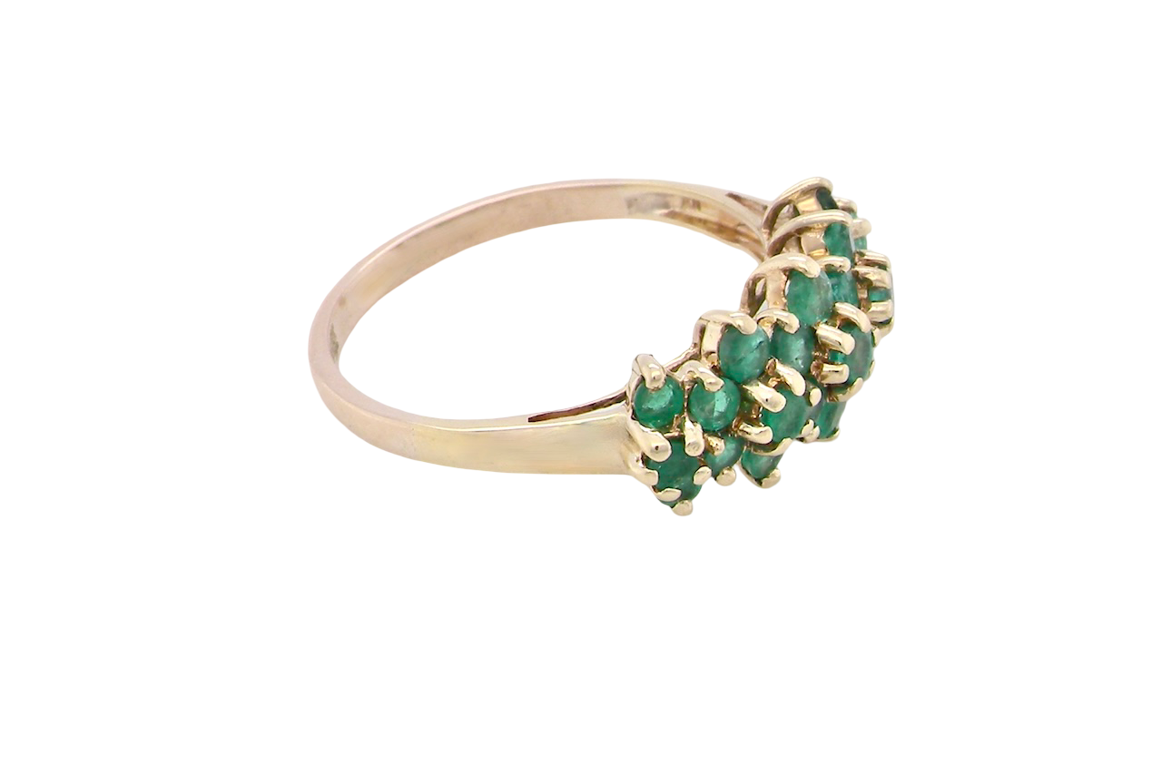 side A striking and unusual dress ring, designed with multiple clusters of round-cut emeralds set beautifully across the finger for a bold, eye-catching look.