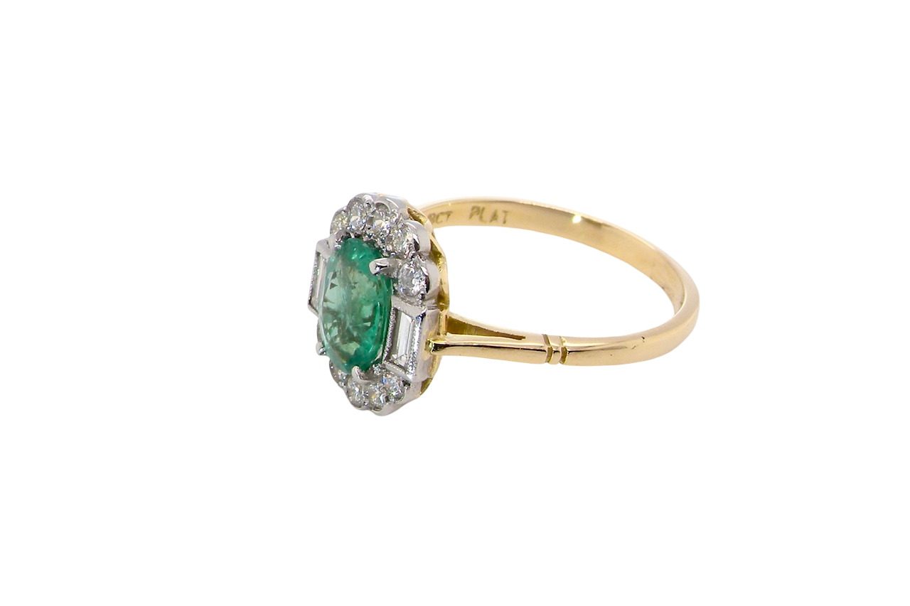 side A stunning vintage cluster ring, set with an oval-cut emerald measuring 8 x 6mm, approximately 1.10 carats. The emerald displays a rich, deep grass-green colour with natural inclusions, typical of a genuine stone.
