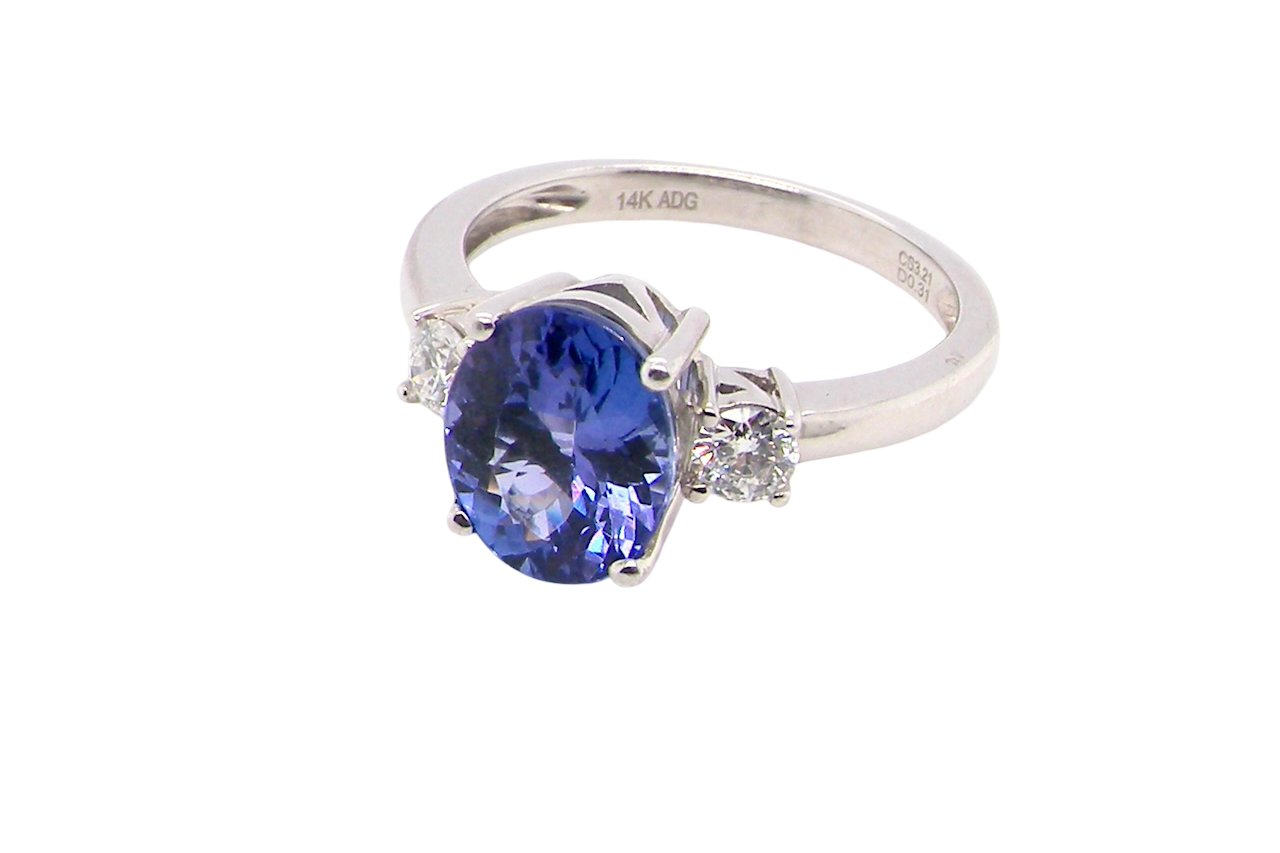 side A three stone ring that features an impressive tanzanite centre stone that measures 10x8mm (3.21 carats confirmed) AAA colour. 