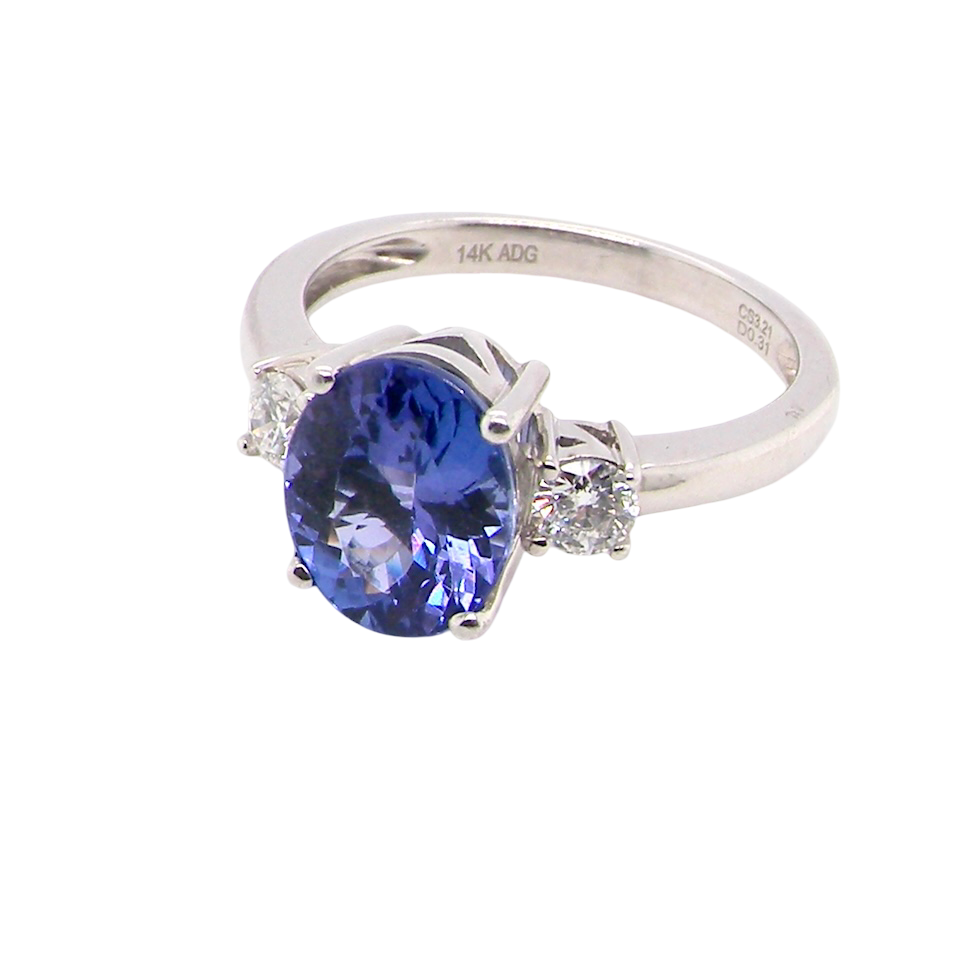 side A three stone ring that features an impressive tanzanite centre stone that measures 10x8mm (3.21 carats confirmed) AAA colour. 