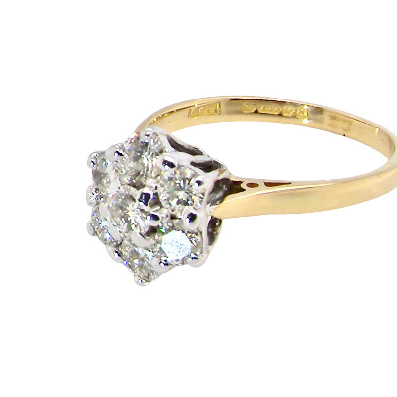 side A traditional cluster ring. Features to the centre a 3.4mm brilliant cut white diamond (est 0.15 carats)
Surrounded by six 3.4mm diamonds to match