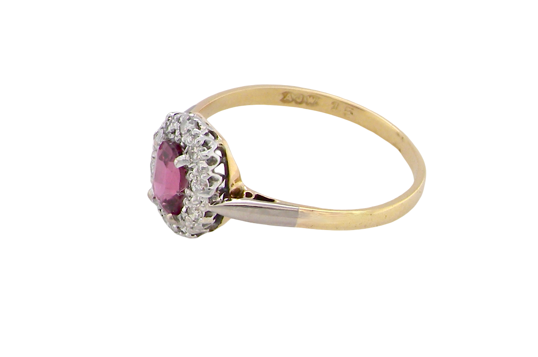 side A traditional cluster ring. Features to the centre a dark pink red ruby, oval cut 6x4mm (0.50 carats)