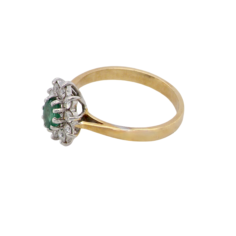 side A traditional cluster ring. Features to the centre an oval shaped emerald, 5.5x4.5mm (est 0.35 carats) deep green colour. 