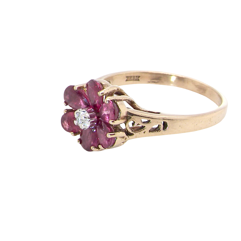 side A very pretty 9 carat gold cluster ring. The centre stone a small illusion set diamond, 1.3mm
Surrounded by six pear shaped raspberry red rubies,
