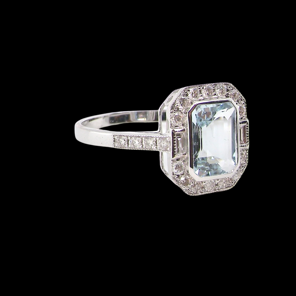 side A very pretty cluster ring. Features a step cut aquamarine centre stone, 8x7mm (est 1.21 carats). Plain rim setting.