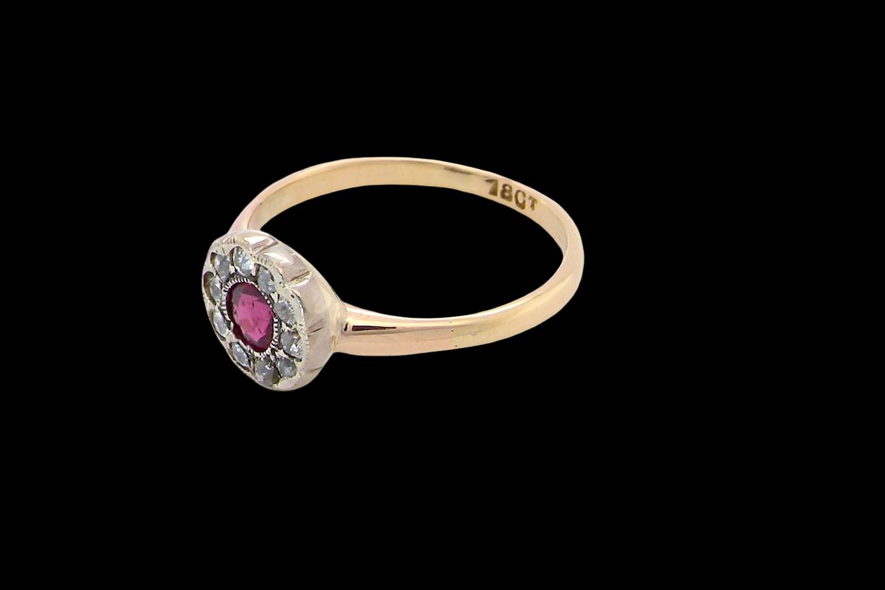 side A very pretty vintage daisy cluster ring. Features to the centre a round pink red ruby that measures 4mm, and is mille grain set.
