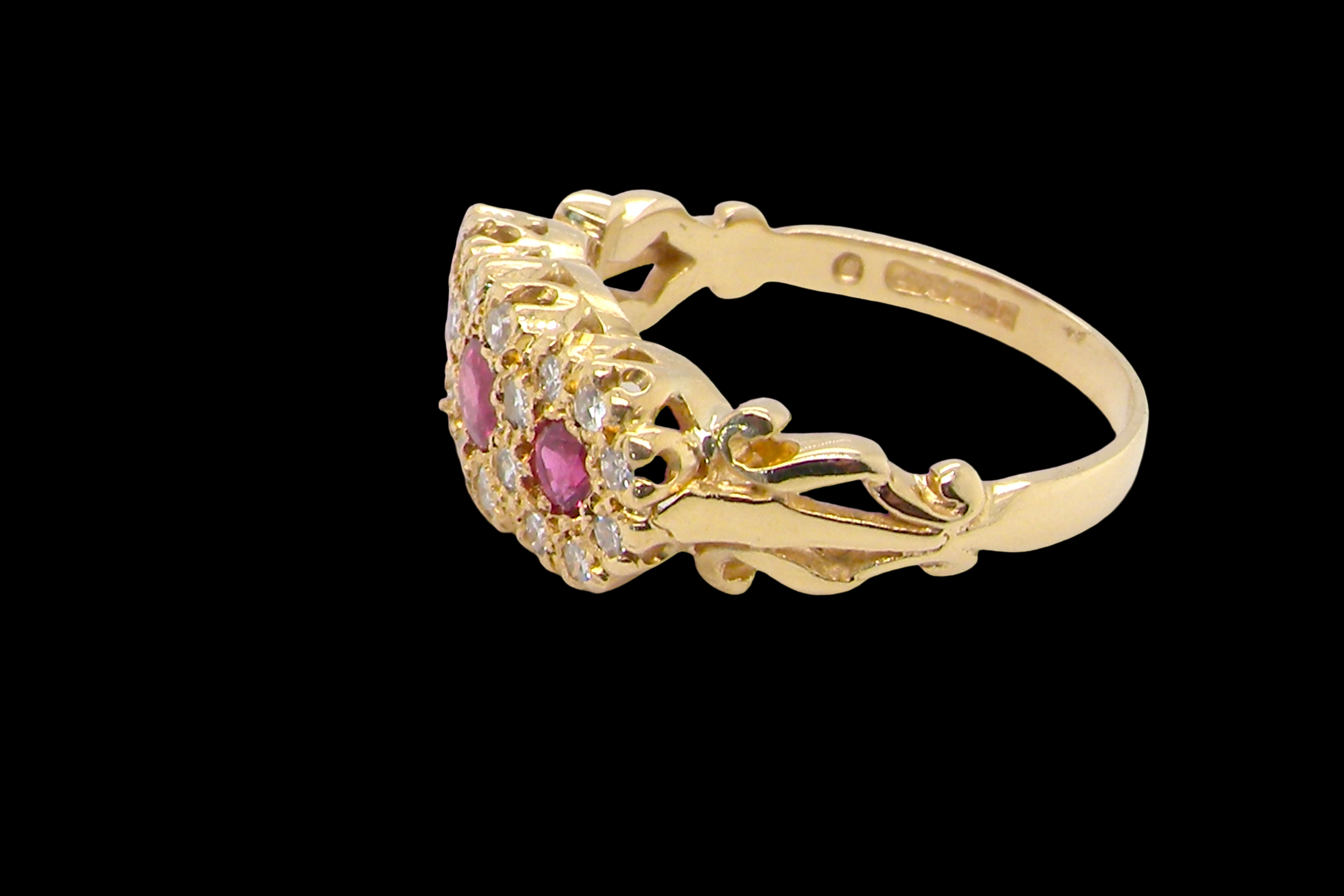 Gold ring with pink gemstones on a black background