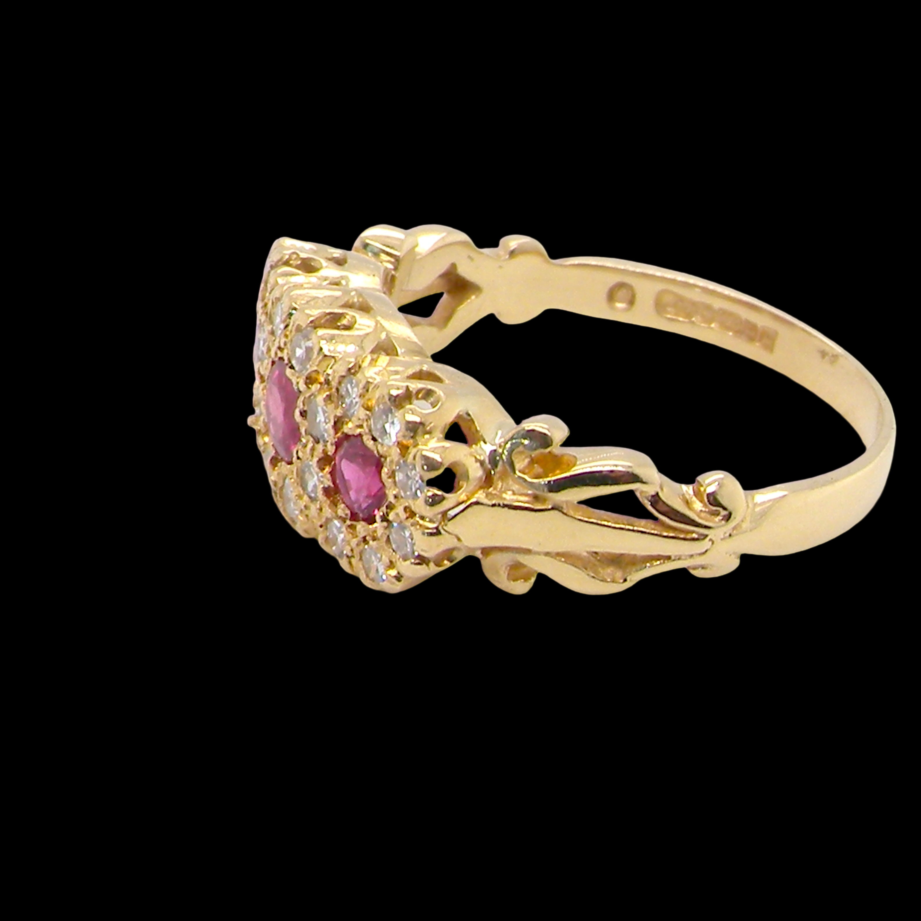 Gold ring with pink gemstones on a black background