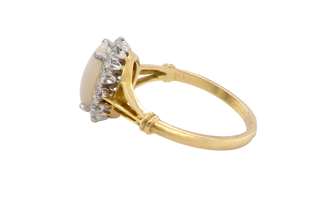 side A vintage cluster ring. Features an oval white opal, measures 10x8mm, with a good play of colour.