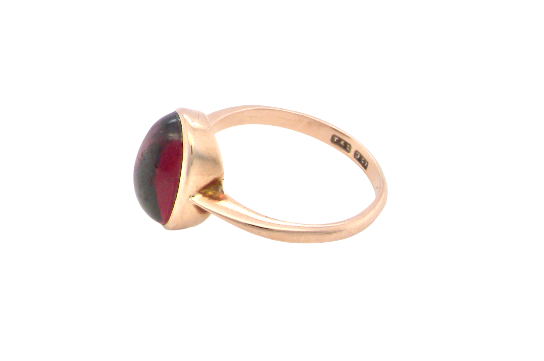 side A vintage dress ring. Set with an oval cabouchon cut garnet, 11x7mm, in a rim style setting.