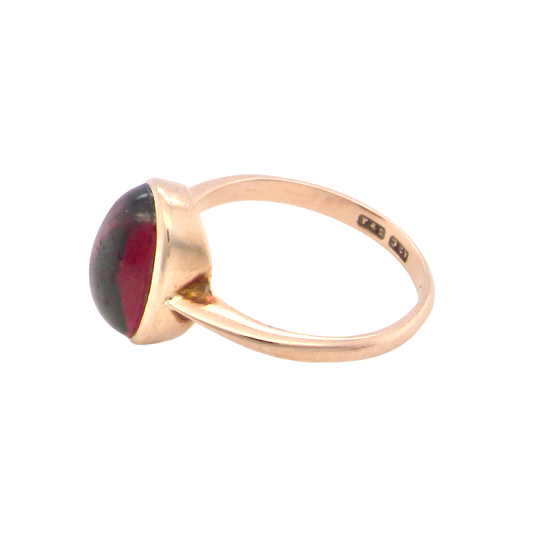 side A vintage dress ring. Set with an oval cabouchon cut garnet, 11x7mm, in a rim style setting.