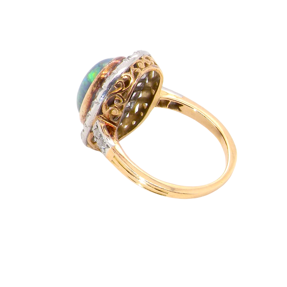 side A vintage early 20th century cluster ring. Features to the centre a black opal doublet, with an excellent play of colour, measures 9.5x7.5mm, in a rim setting.