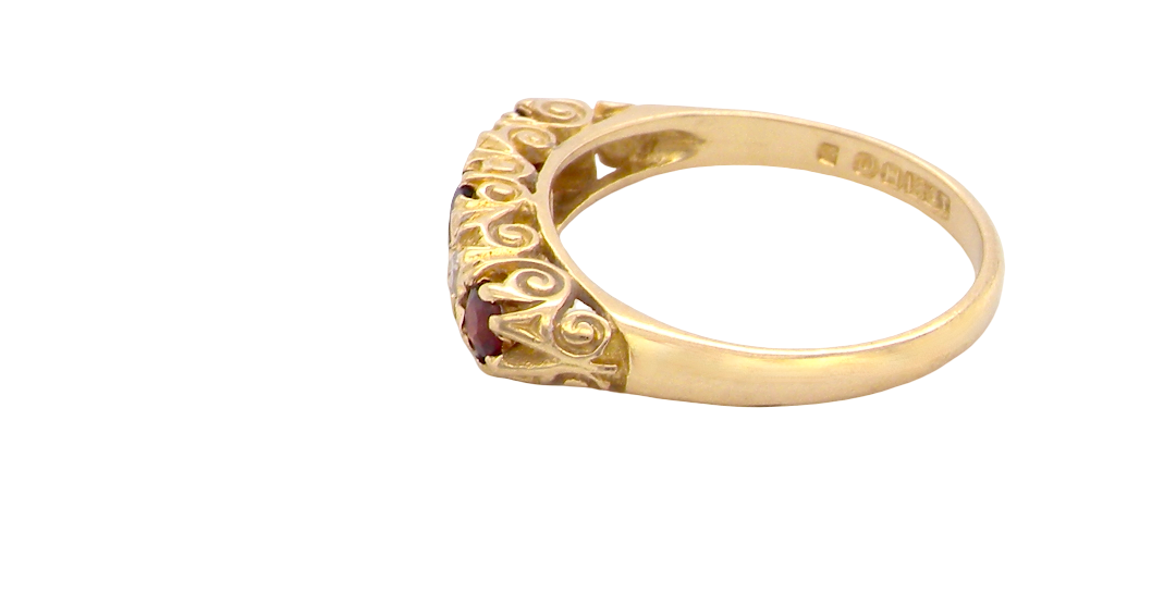 side A vintage style 18 carat gold boat shaped ring. Features three dark red garnets, centre 4mm, each end a 3mm stone. 