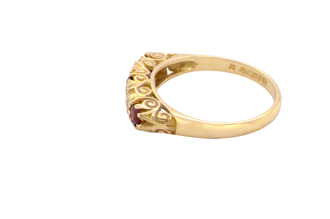 side A vintage style 18 carat gold boat shaped ring. Features three dark red garnets, centre 4mm, each end a 3mm stone. 