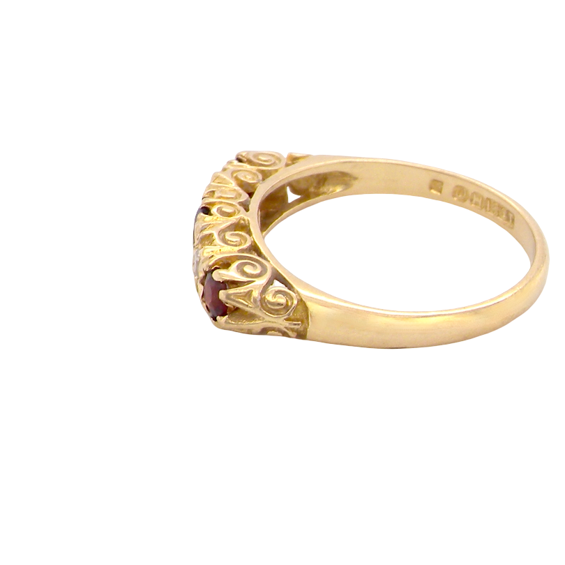 side A vintage style 18 carat gold boat shaped ring. Features three dark red garnets, centre 4mm, each end a 3mm stone. 