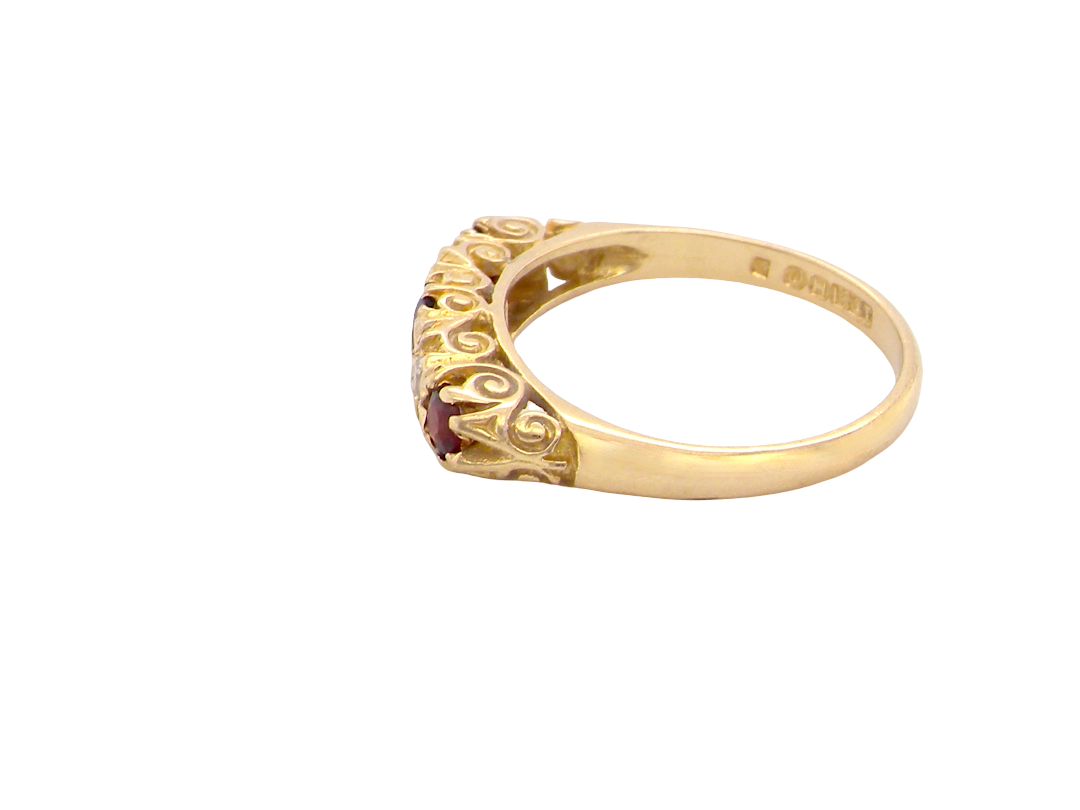 side A vintage style 18 carat gold boat shaped ring. Features three dark red garnets, centre 4mm, each end a 3mm stone. 