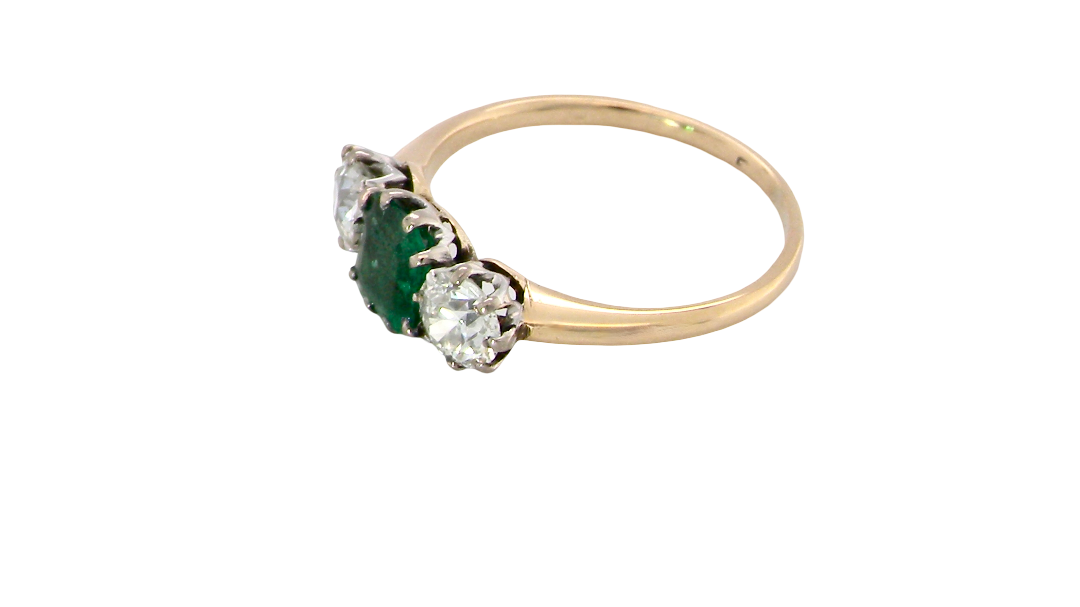 side A vintage trilogy ring. Centre stone a step cut emerald, 6.5x5.5mm (est .75 carats). The emerald is dark green.