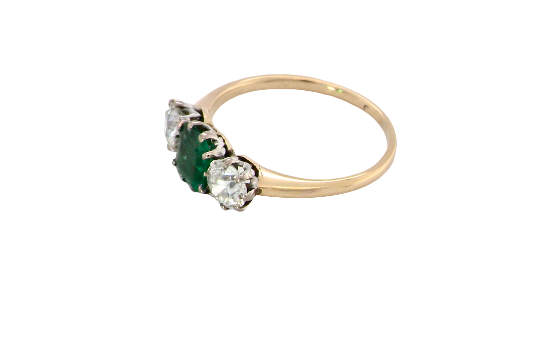 side A vintage trilogy ring. Centre stone a step cut emerald, 6.5x5.5mm (est .75 carats). The emerald is dark green.