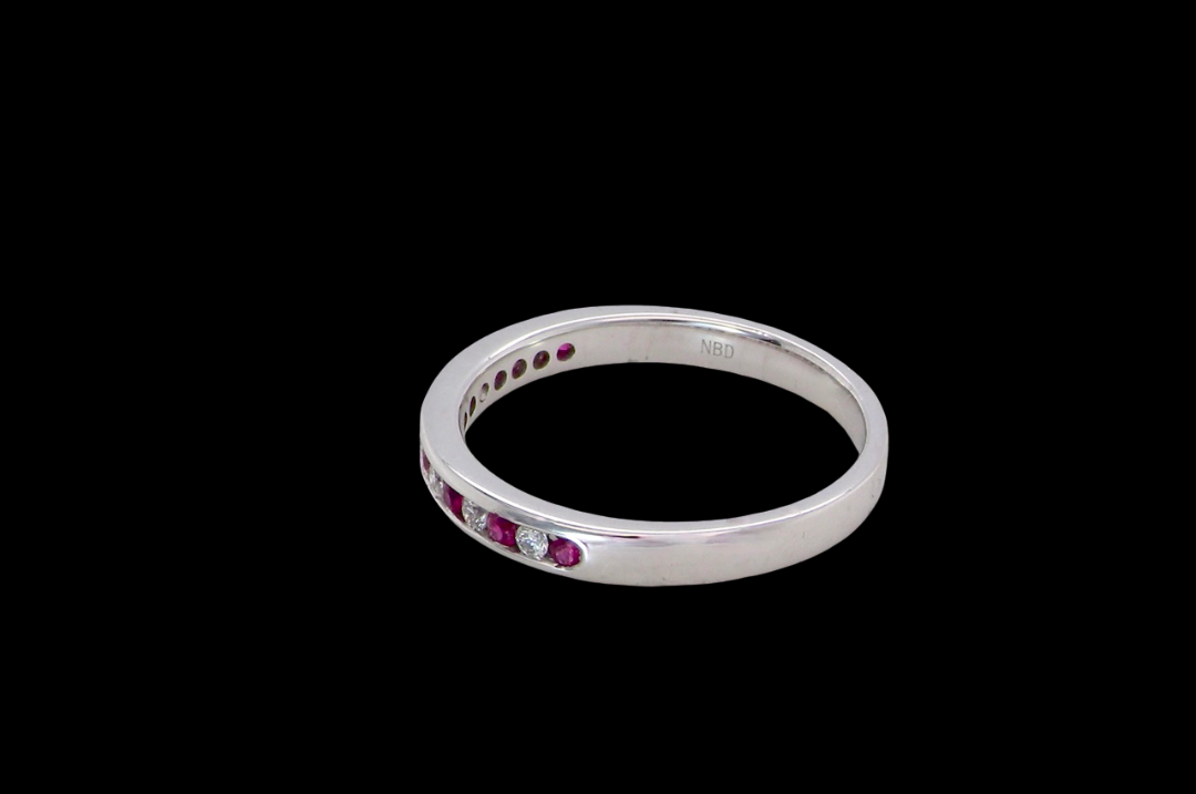 side A white gold half hoop eternity ring. Set with seven round rubies and six brilliant cut white diamonds