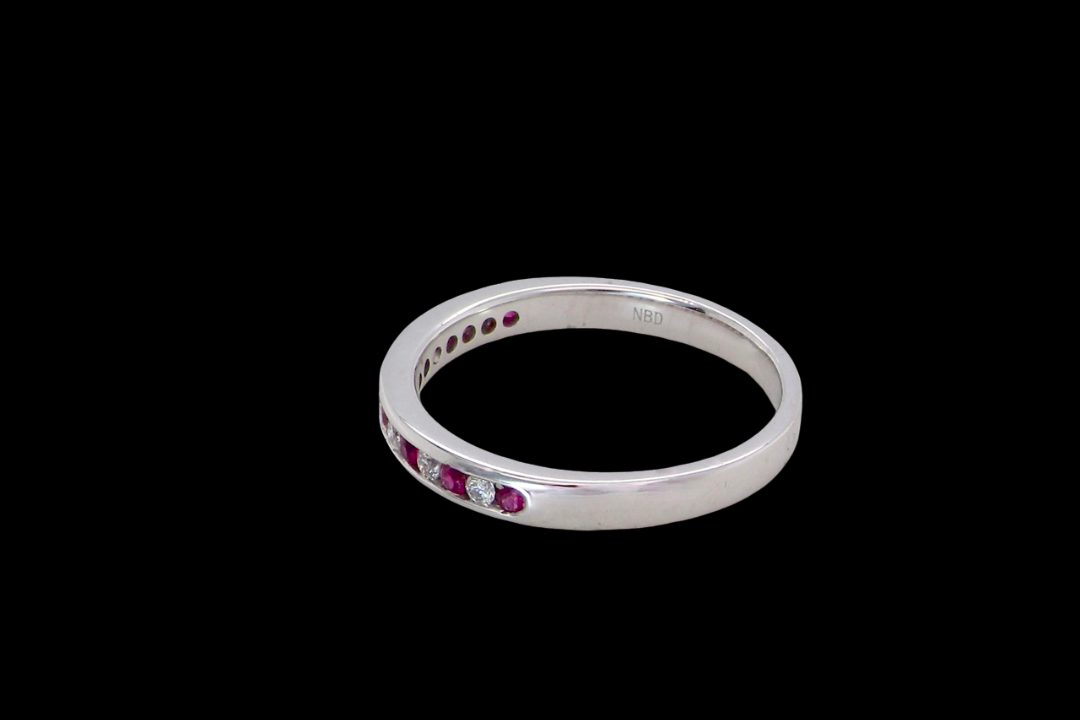 side A white gold half hoop eternity ring. Set with seven round rubies and six brilliant cut white diamonds