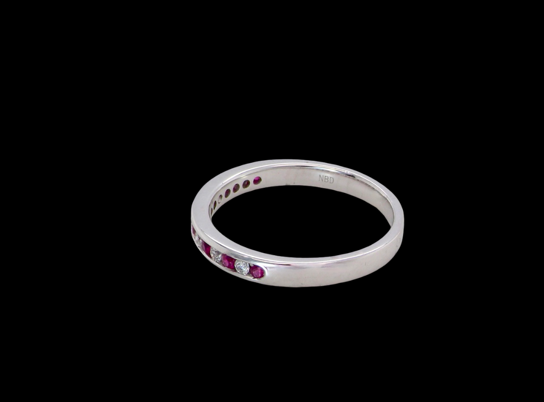 side A white gold half hoop eternity ring. Set with seven round rubies and six brilliant cut white diamonds