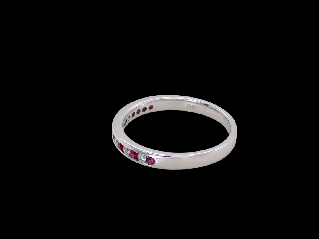 side A white gold half hoop eternity ring. Set with seven round rubies and six brilliant cut white diamonds