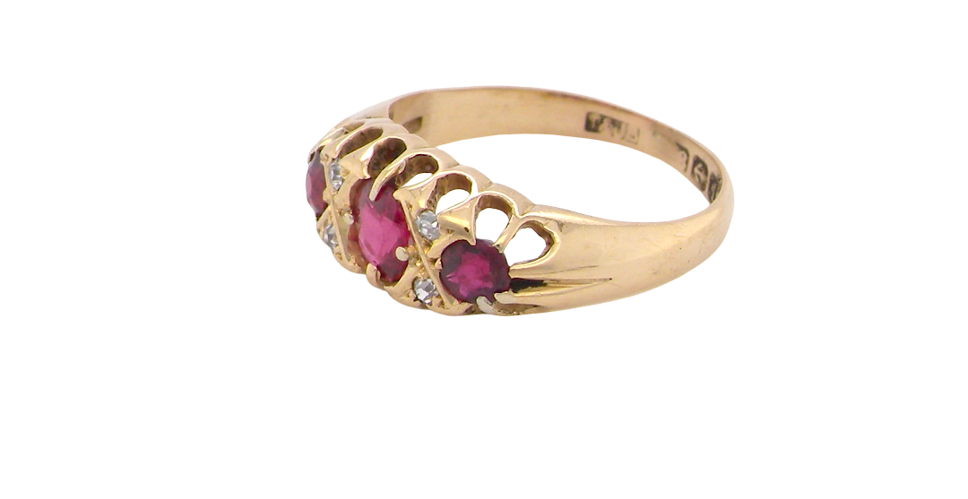side An 18 carat gold antique boat shaped ring. Features three lovely coloured wine red rubies, centre 5x4mm, each end 2.4mm.