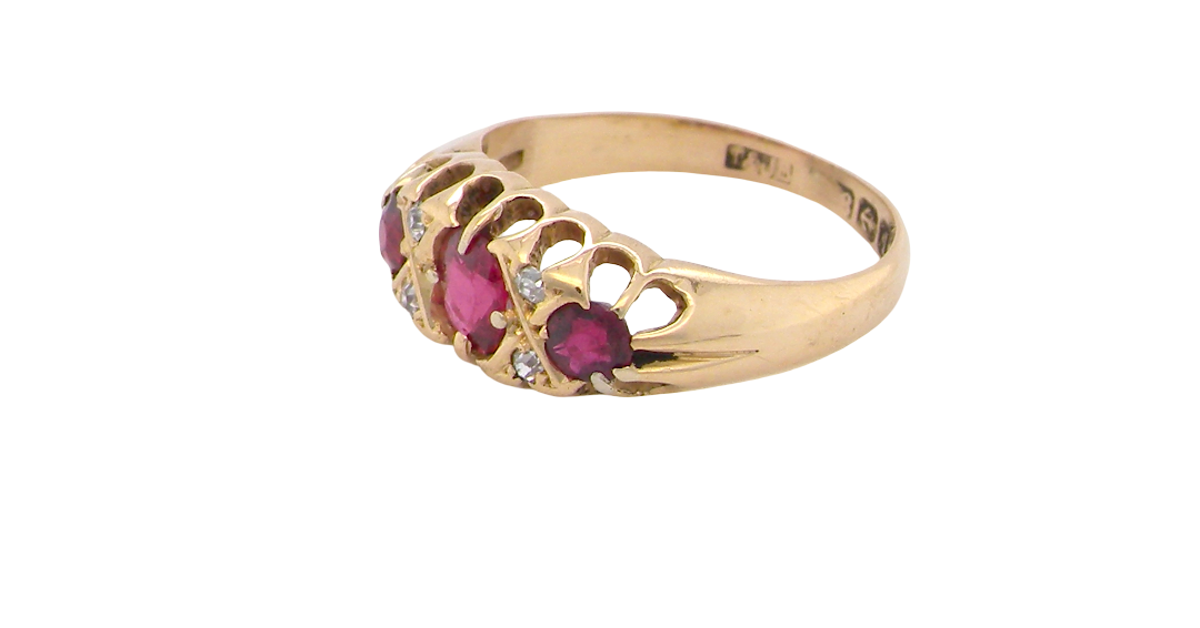 side An 18 carat gold antique boat shaped ring. Features three lovely coloured wine red rubies, centre 5x4mm, each end 2.4mm.