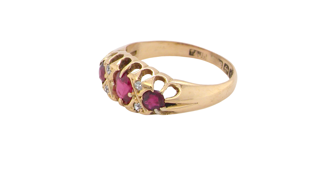 side An 18 carat gold antique boat shaped ring. Features three lovely coloured wine red rubies, centre 5x4mm, each end 2.4mm.