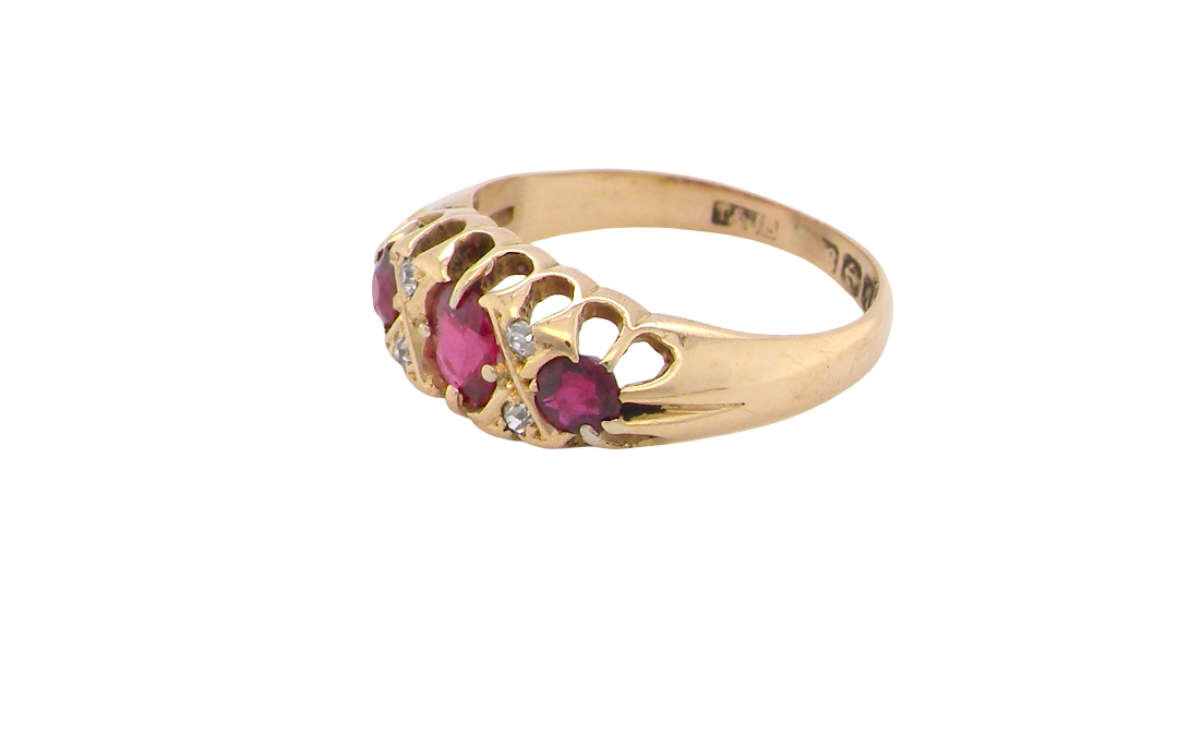 side An 18 carat gold antique boat shaped ring. Features three lovely coloured wine red rubies, centre 5x4mm, each end 2.4mm.