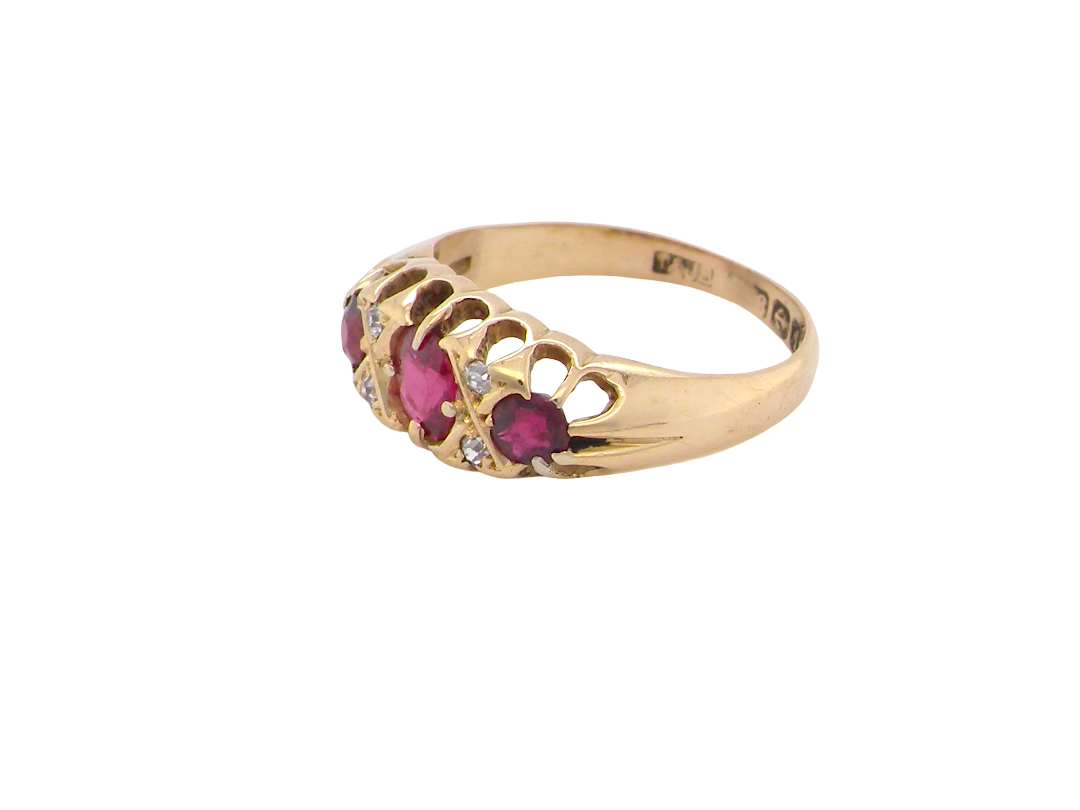 side An 18 carat gold antique boat shaped ring. Features three lovely coloured wine red rubies, centre 5x4mm, each end 2.4mm.