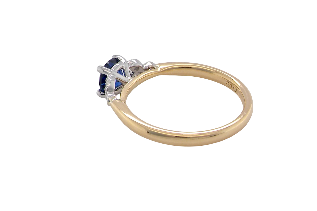 side An 18 carat gold ring set with a vibrant blue sapphire,