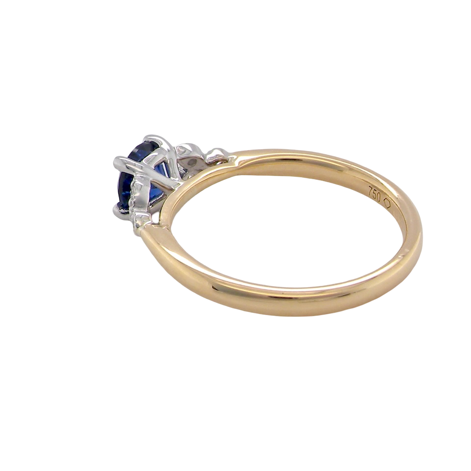 side An 18 carat gold ring set with a vibrant blue sapphire,