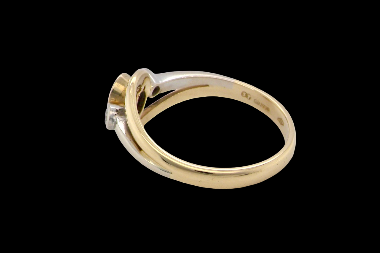 side An 18 carat gold three-stone ring featuring a rich, oval-cut dark blue sapphire at the centre, measuring 5 × 4mm, secured in a classic rim (bezel) setting.