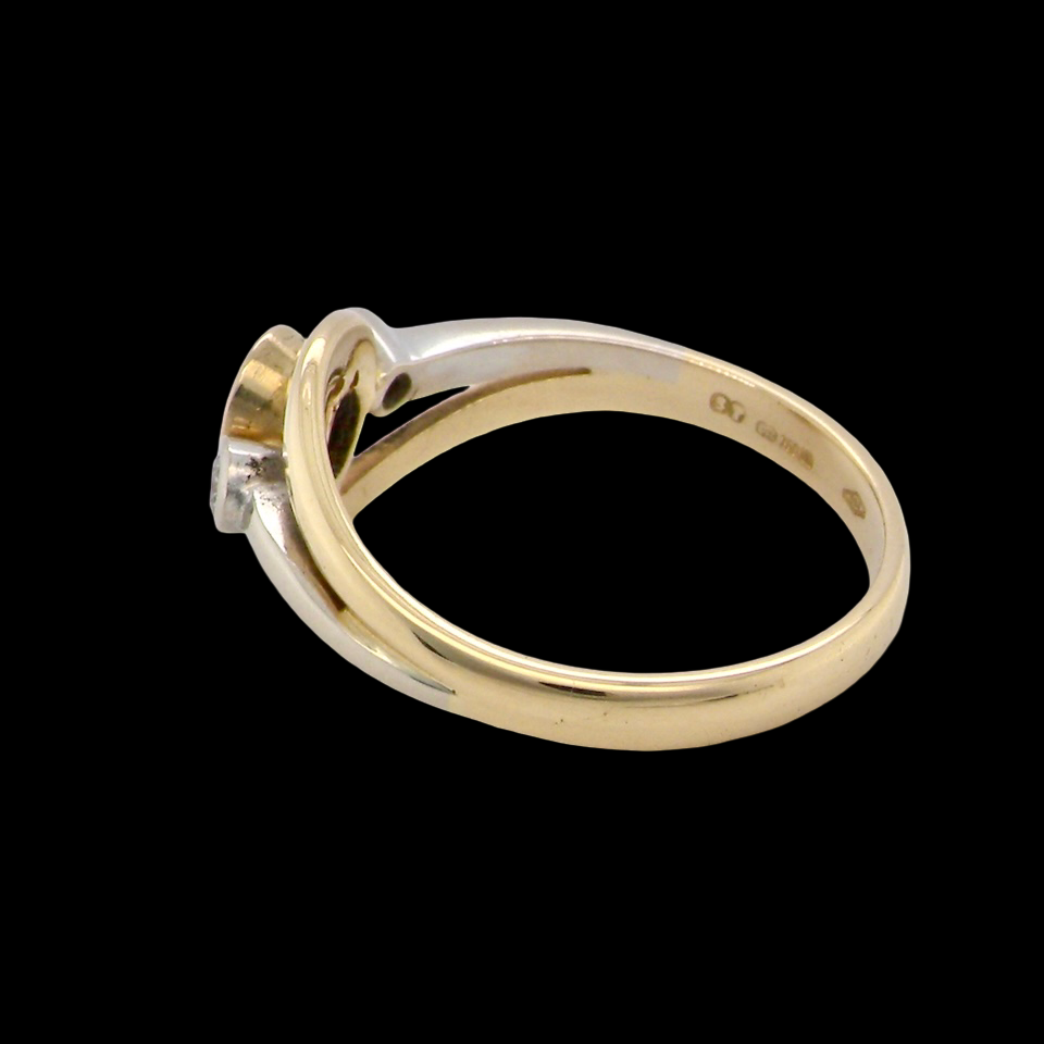 side An 18 carat gold three-stone ring featuring a rich, oval-cut dark blue sapphire at the centre, measuring 5 × 4mm, secured in a classic rim (bezel) setting.