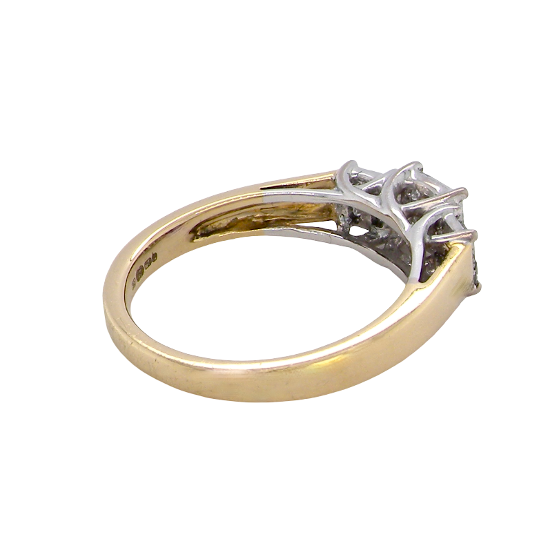 A two-tone diamond ring with a yellow gold band and a silver-colored setting featuring three prongs, photographed on a solid white background.
