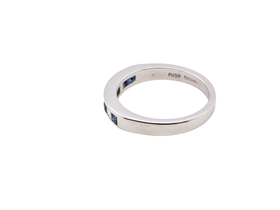 side An 18 carat white gold half hoop eternity ring. Set with princess cut white diamonds, total of four- estimated 0.40 carats (2.4mm each) colour H-j, clarity Si.