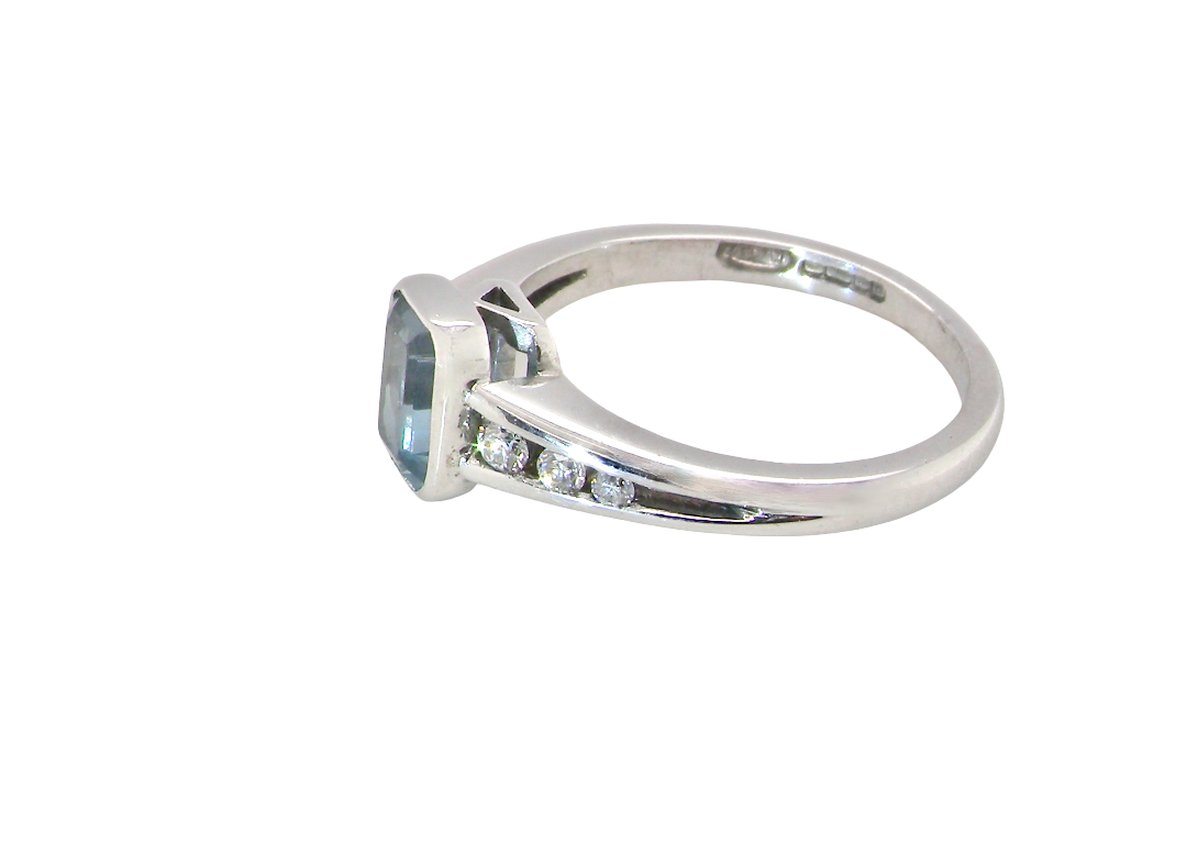 side An 18 carat white gold ring, features a rectangular step cut aquamarine, measures 7x5mm (st one carat) sky blue, fine clarity. Rim setting.