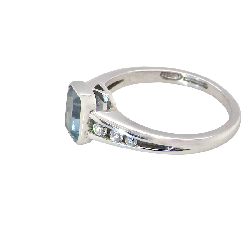 side An 18 carat white gold ring, features a rectangular step cut aquamarine, measures 7x5mm (st one carat) sky blue, fine clarity. Rim setting.