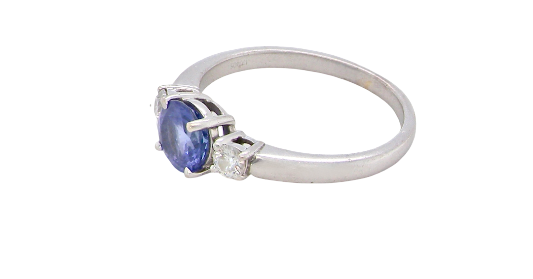 side An 18 carat white gold three stone ring. Centre stone a round tanzanite 6mm diameter.
Each side a brilliant cut white diamond