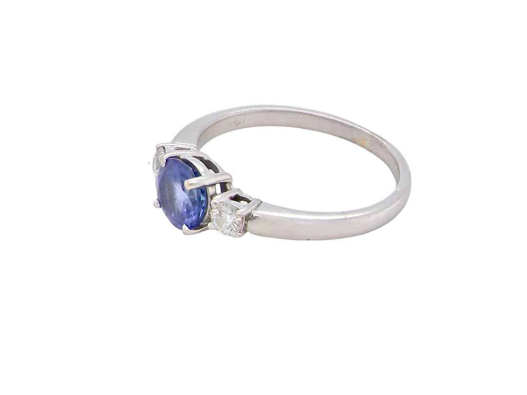 side An 18 carat white gold three stone ring. Centre stone a round tanzanite 6mm diameter.
Each side a brilliant cut white diamond