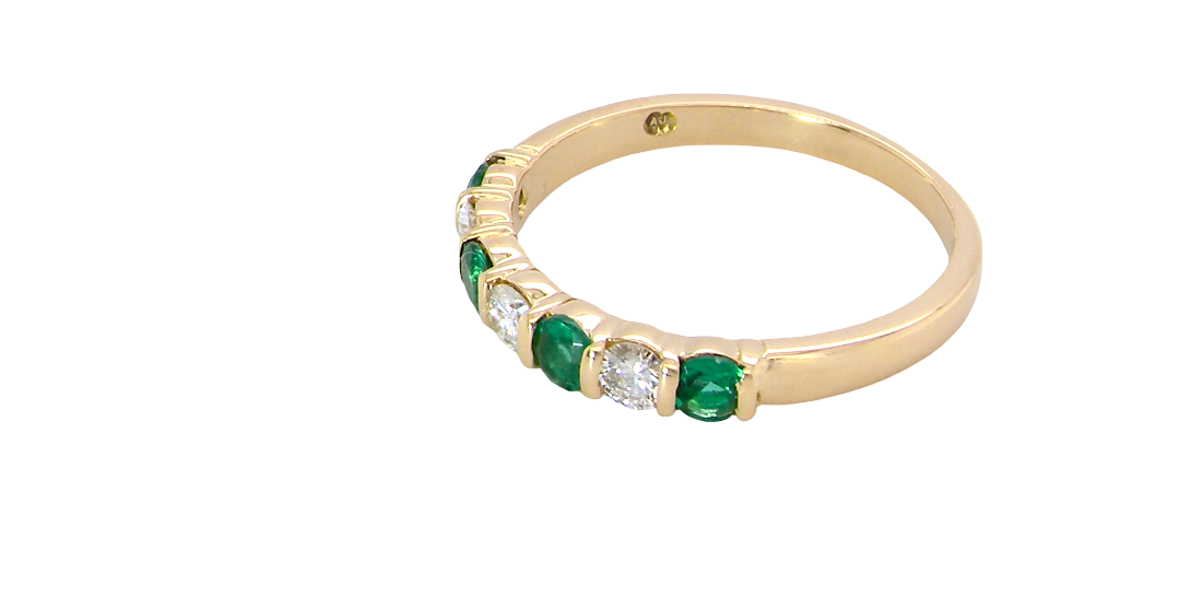 side An 18 carat yellow gold half hoop eternity ring. Set with four bright green emeralds, each 3mm diameter (est each 0.10 carats) .