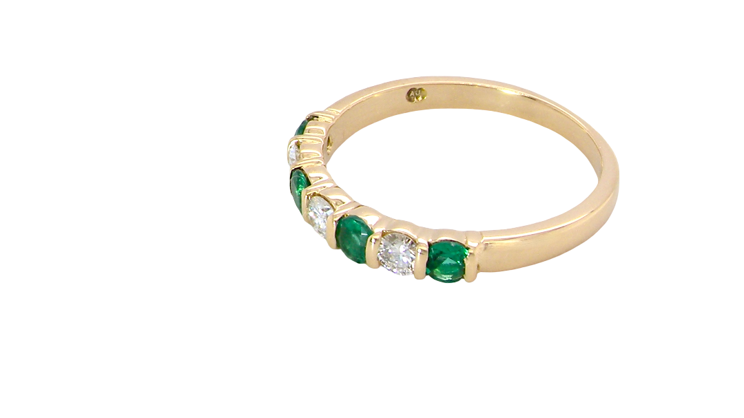 side An 18 carat yellow gold half hoop eternity ring. Set with four bright green emeralds, each 3mm diameter (est each 0.10 carats) .