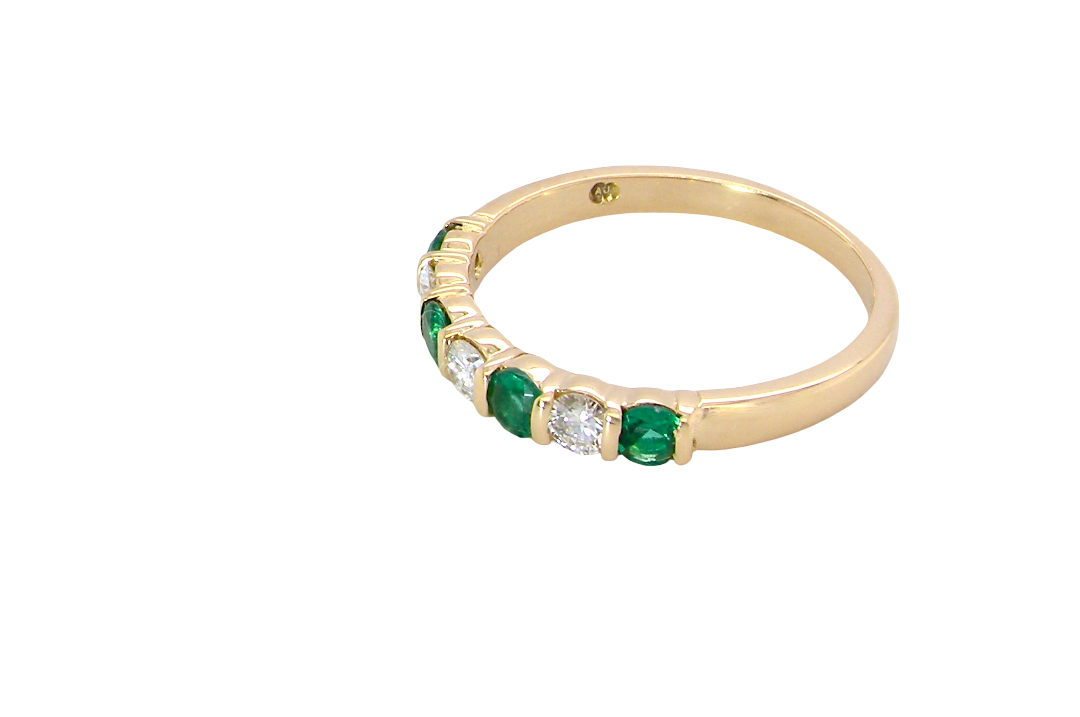 side An 18 carat yellow gold half hoop eternity ring. Set with four bright green emeralds, each 3mm diameter (est each 0.10 carats) .