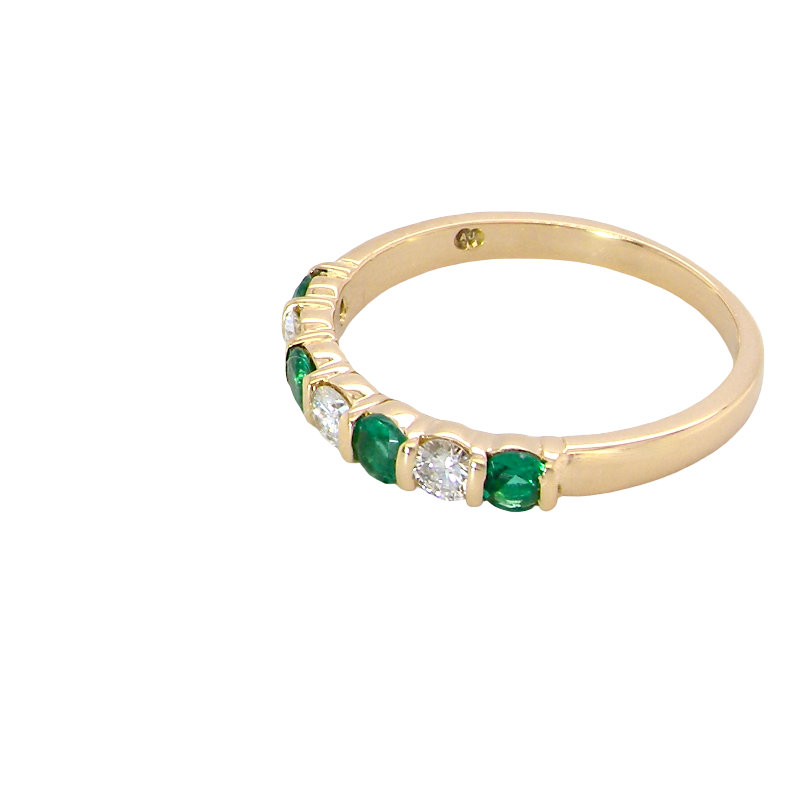 side An 18 carat yellow gold half hoop eternity ring. Set with four bright green emeralds, each 3mm diameter (est each 0.10 carats) .